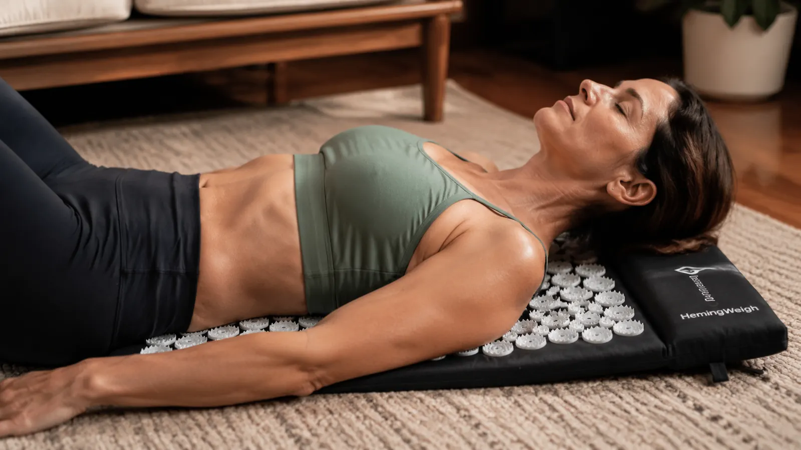 A person lying back on an acupressure mat with their shoulders and upper back pressed into the spikes