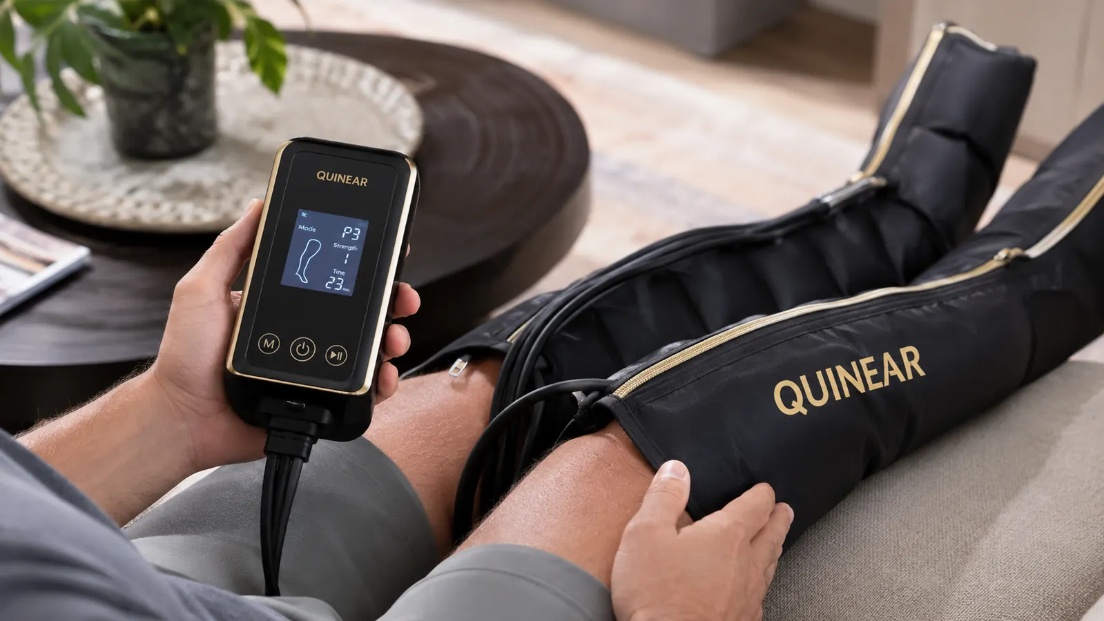 Hand pressing the control button on the QUINEAR compression boot handheld unit while the boot inflates around a calf