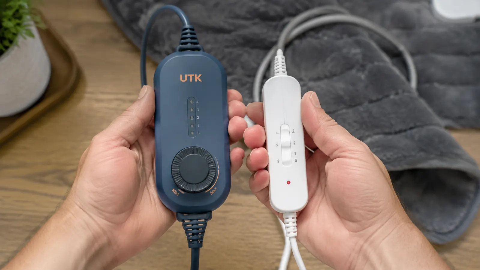Close-up of a hand holding the UTK heating pad controller cord next to the flat cord of a basic drugstore heating pad for comparison